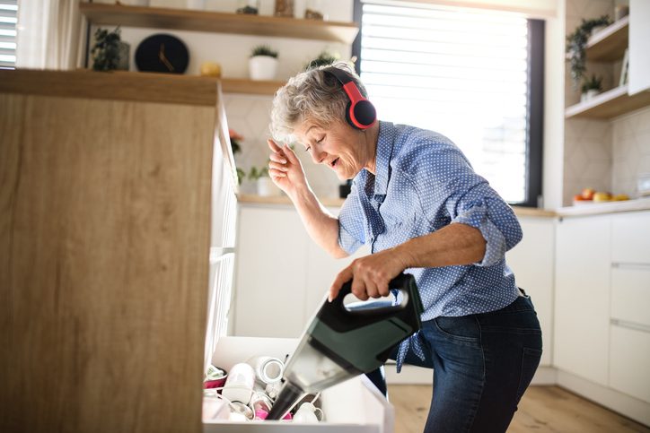 woman vacuums wearing headphones