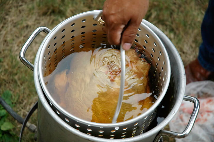 Pulling a turkey out of a deep fryer
