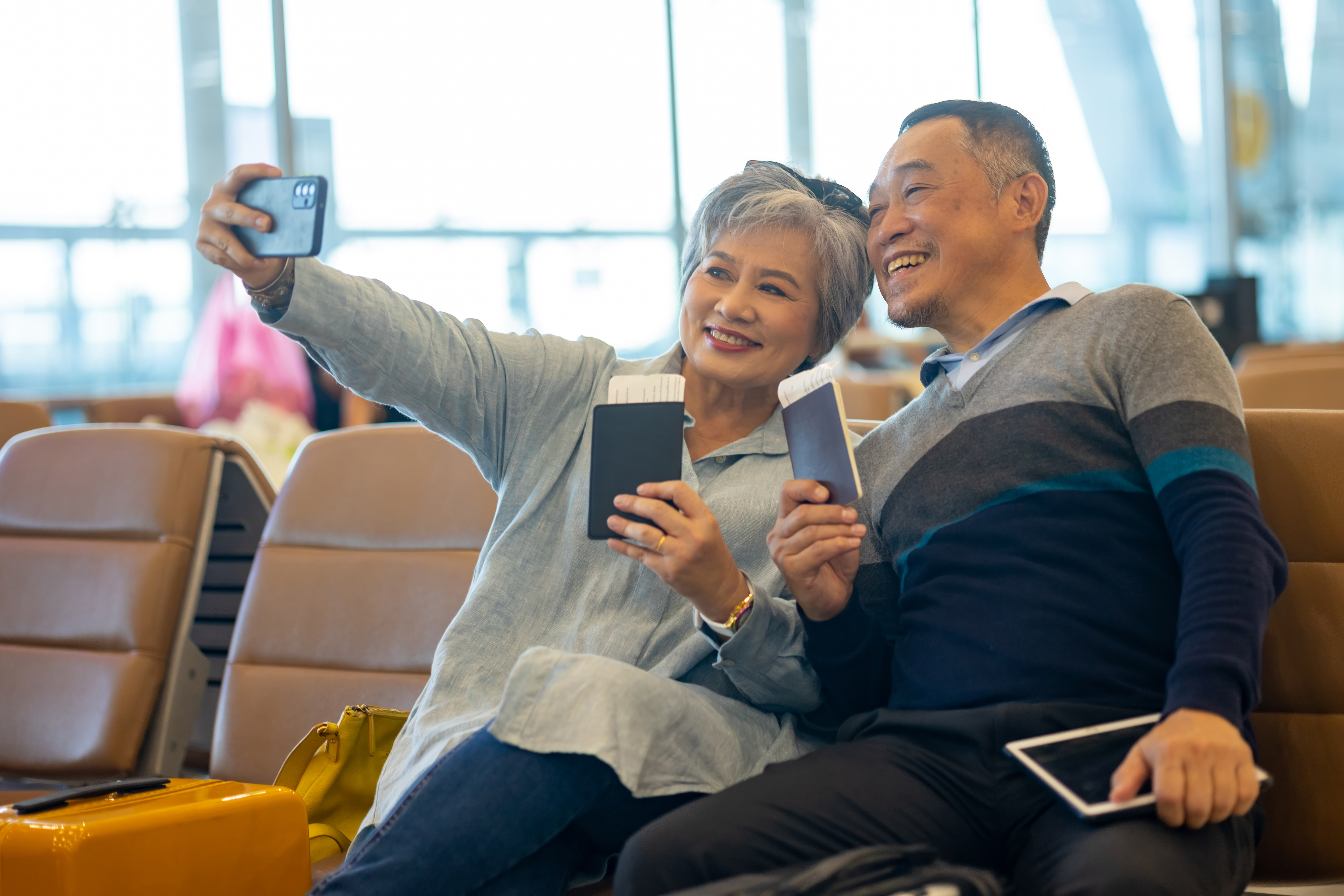 A couple poses with their passports before a trip