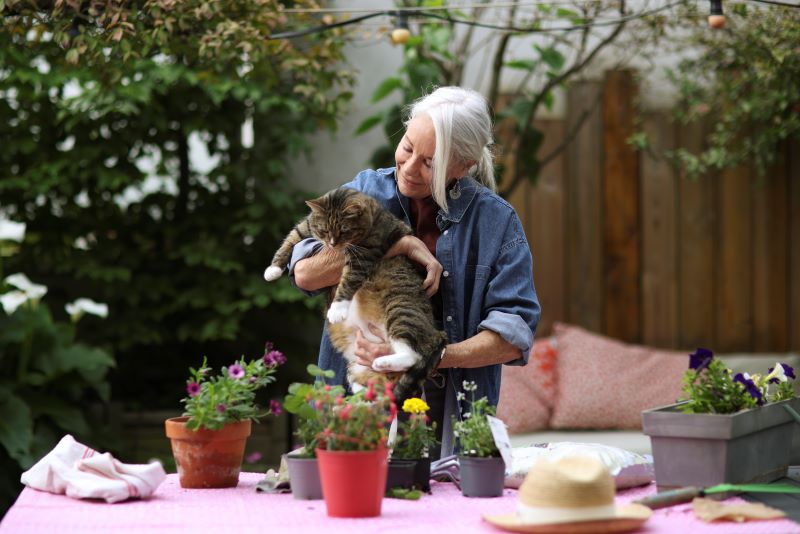 woman holding striped cat outside