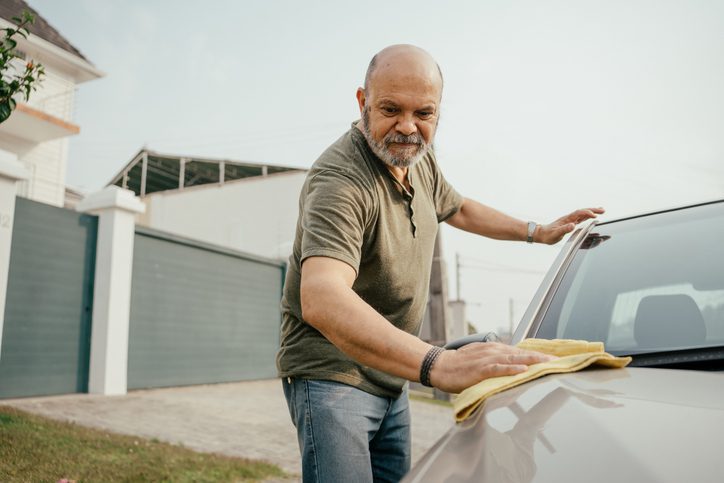 Man drying a car with a cloth