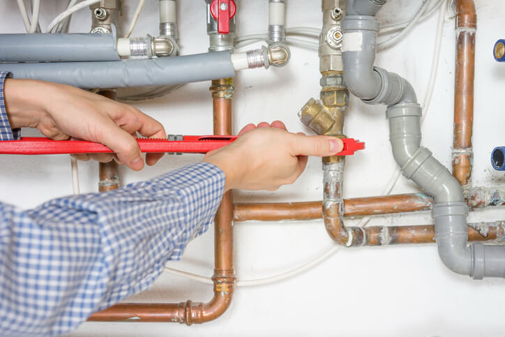 A plumber tightening pipes