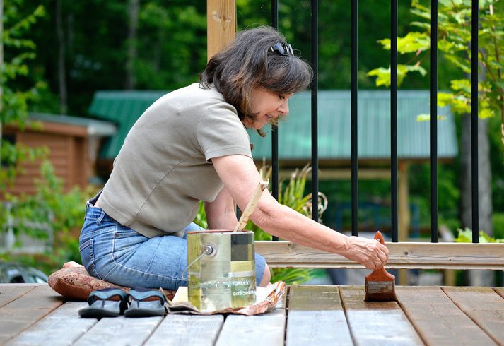 Woman staining a deck