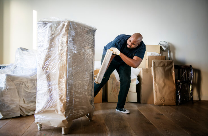 man wraps furniture