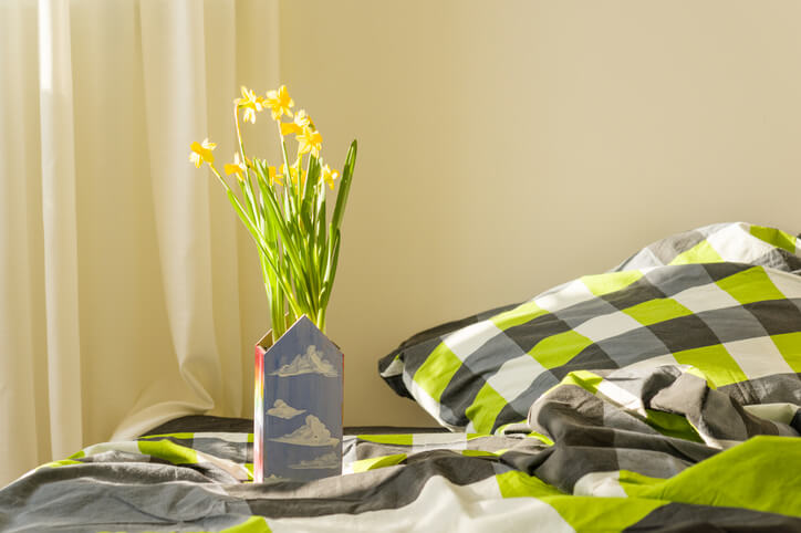 Flowers next to a bed