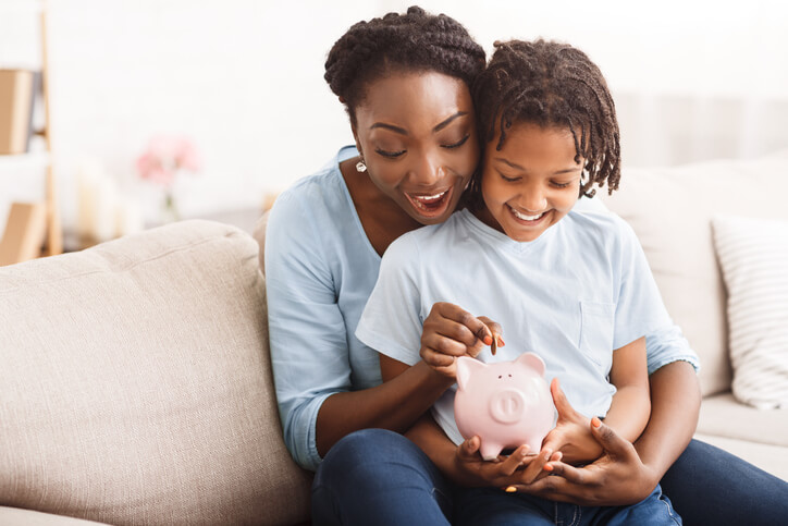 mother and son fill piggy bank