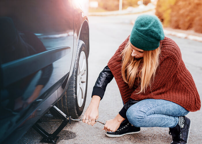 woman changes tire