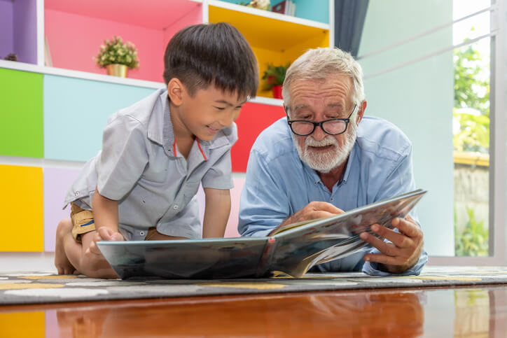 grandson reading with grandfather