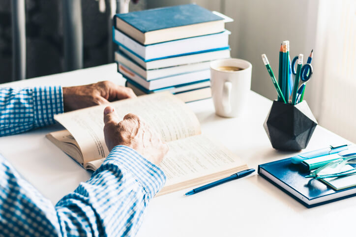 Person reading a book in their home office