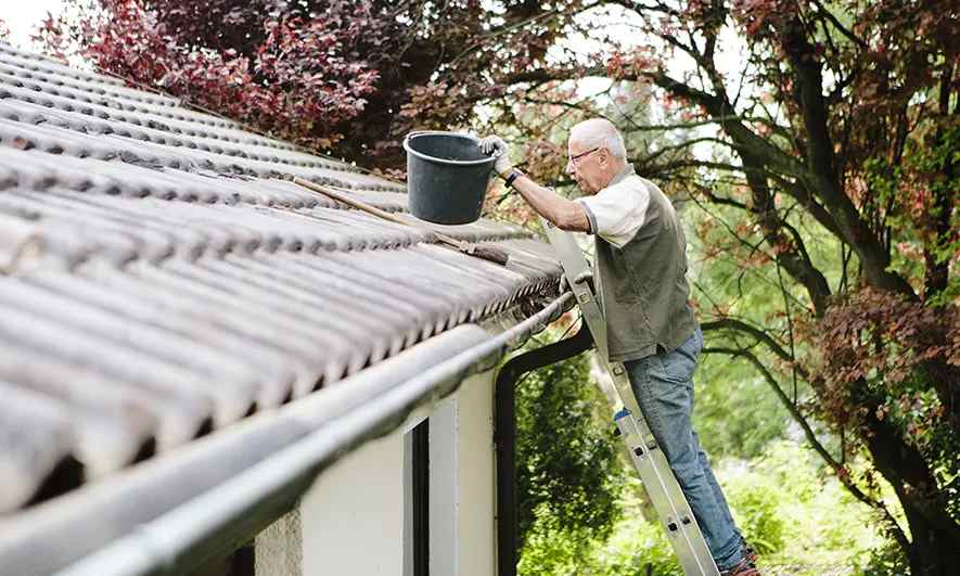 man cleans gutters