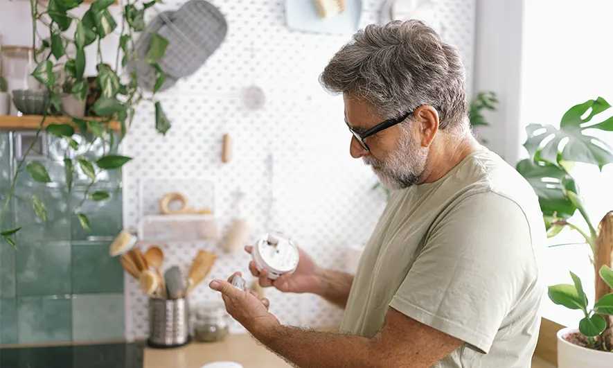 man changes smoke detector batteries