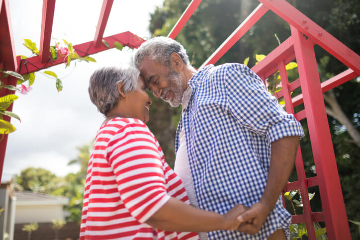 couple holding hands under a trellis