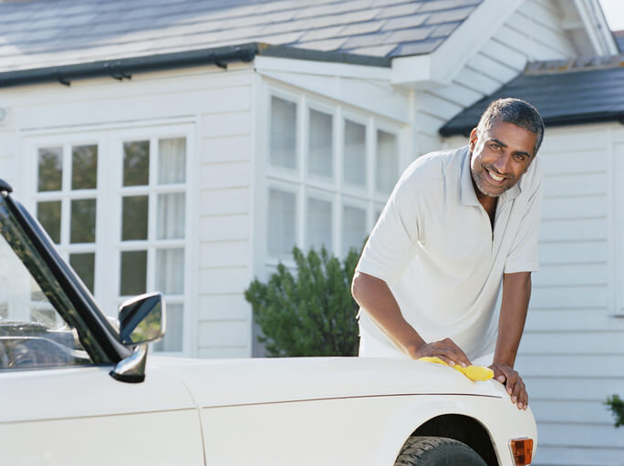 man cleans classic car