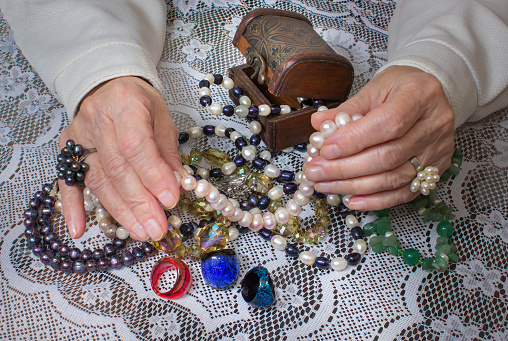 An old woman's hands holding jewelry