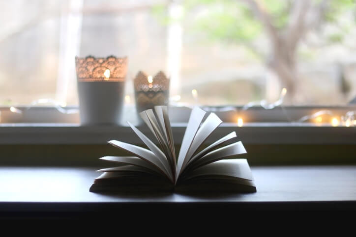 Open book in front of candles