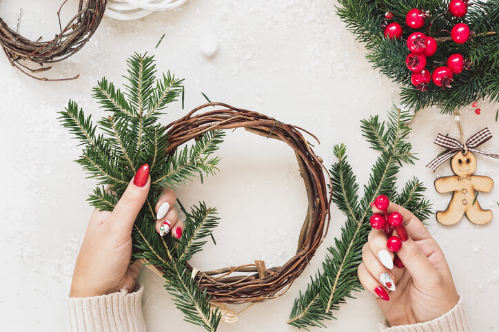 Person holding pine branches, making a wreath