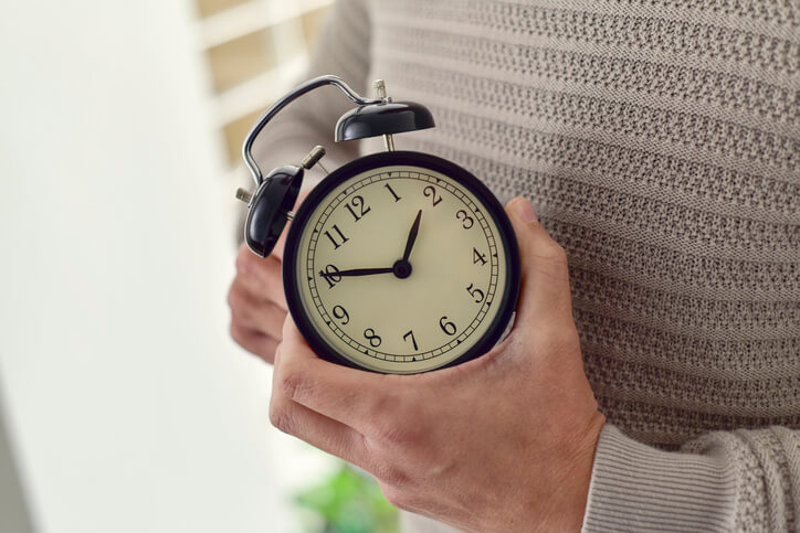 man holds clock