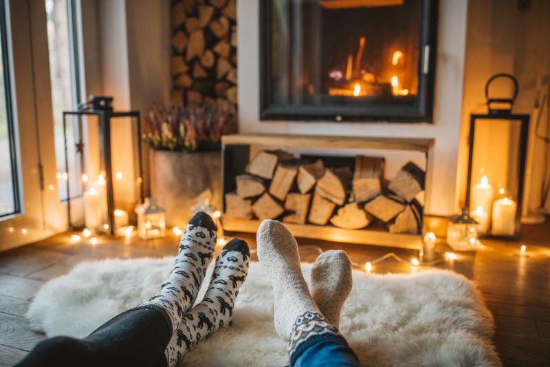 Two people sitting cozily in front of a fire
