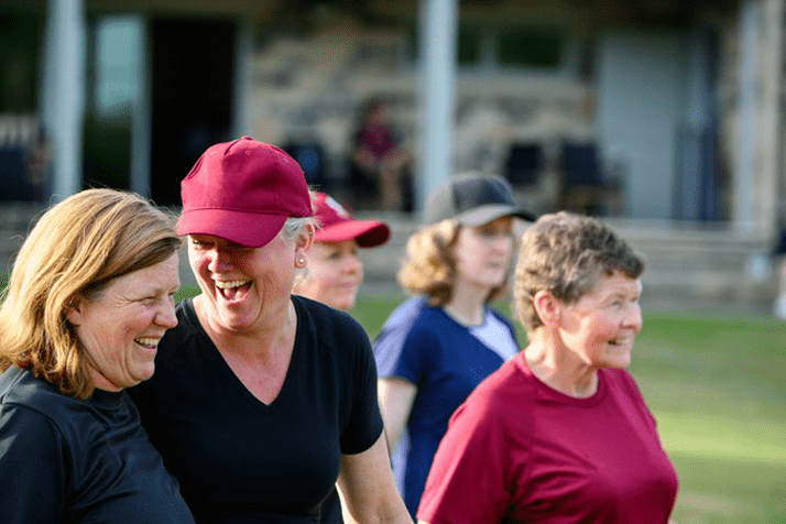 A group of smiling women gathered in a field