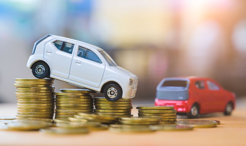 Toy cars on a pile of pennies in decreasing size