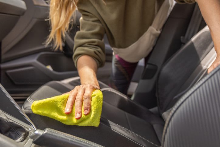 Someone wiping down the interior of a car