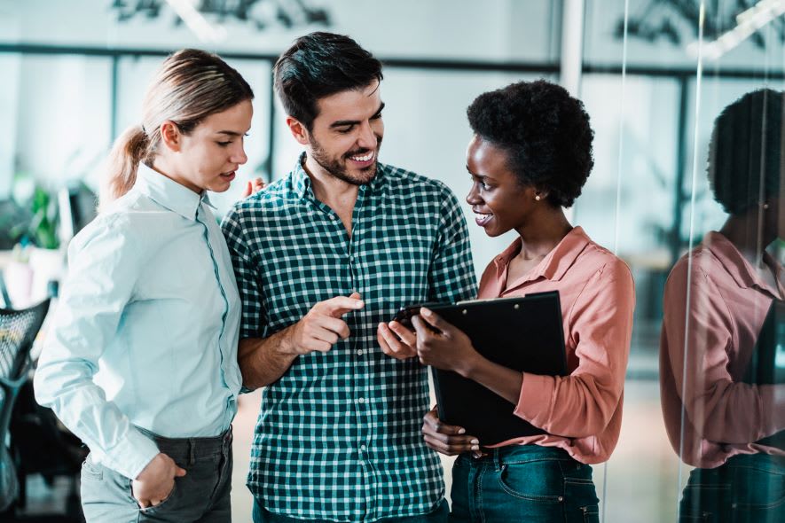 Two women and a man discuss strategic planning in an office.