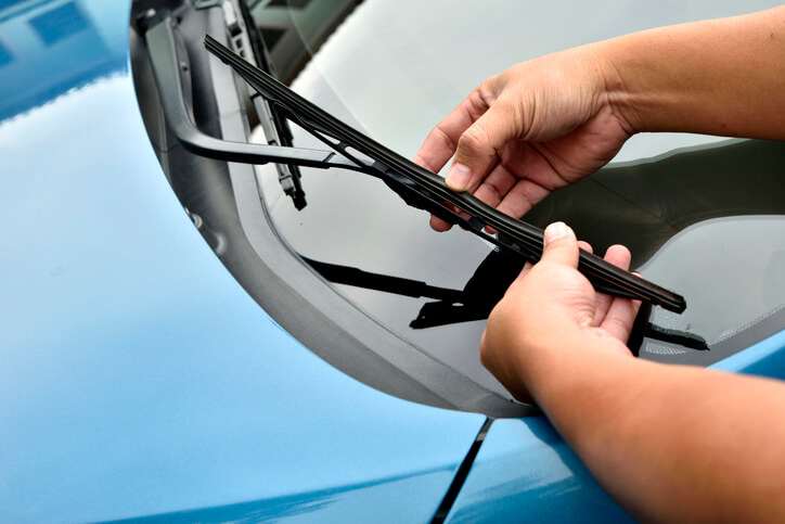 A person removing wiper blades