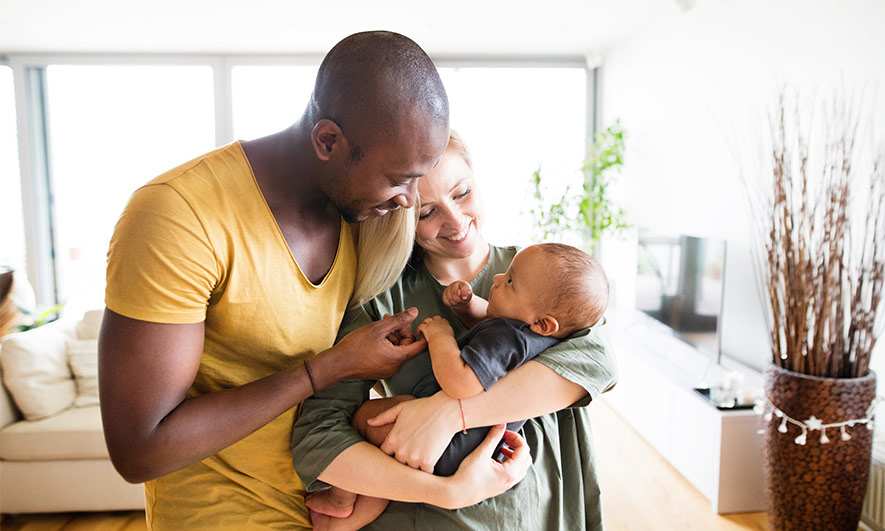 A couple hugging their new baby