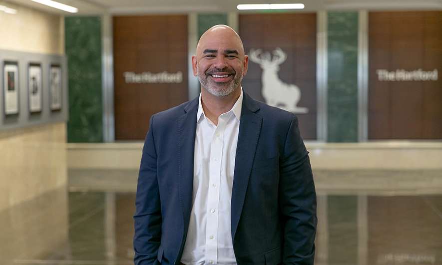 Dustin Kingsbury smiles in the lobby of The Hartford home office