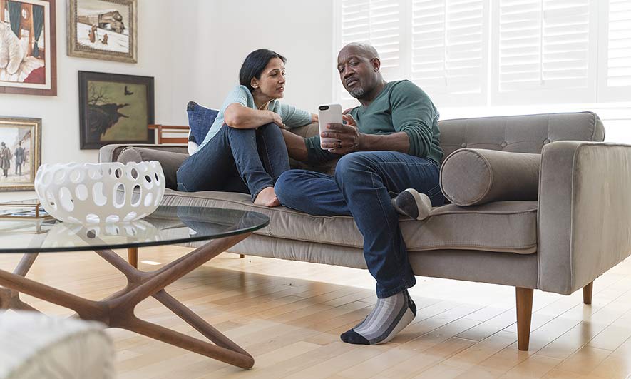 A couple sits together on a couch, talking