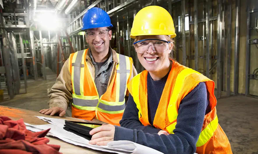 Construction workers reviewing plans at a construction site.