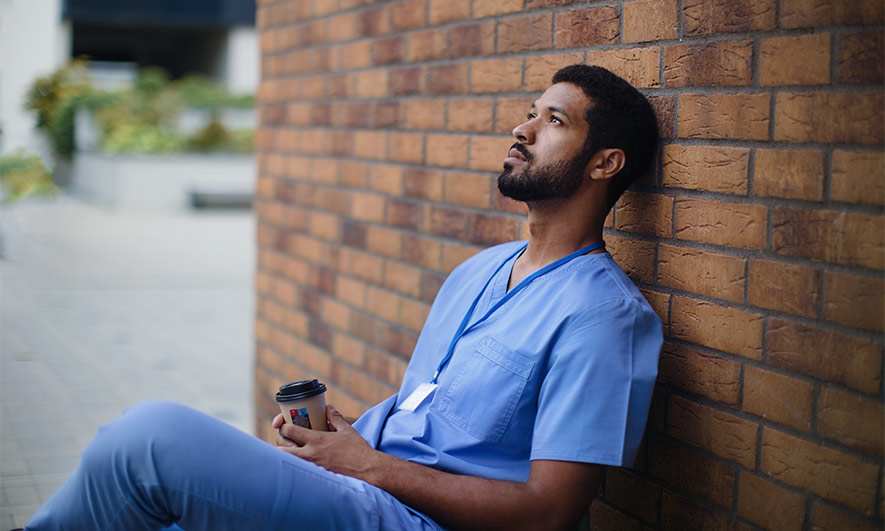 Stressed healthcare worker looking anxious while on his coffee break.