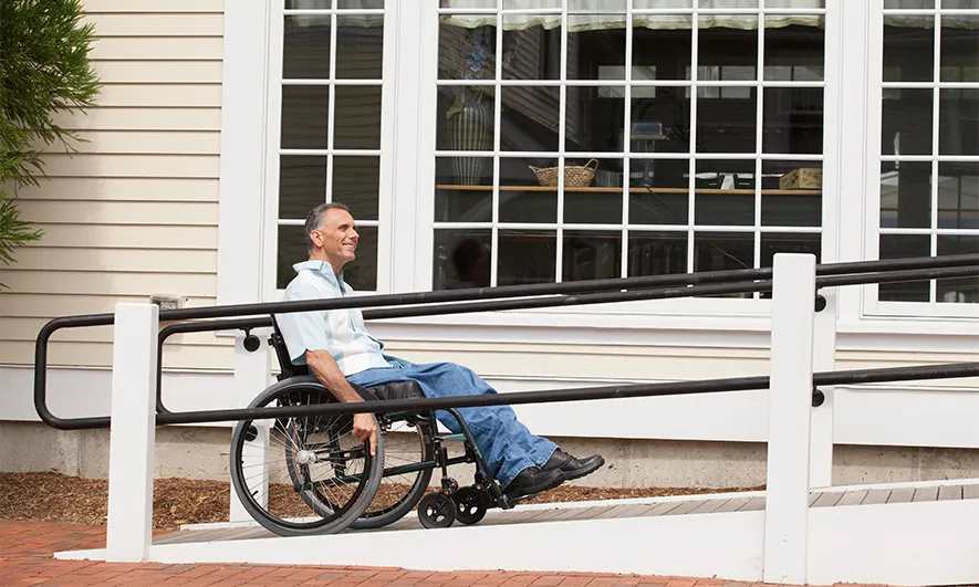 A wheelchair user rolling up a ramp