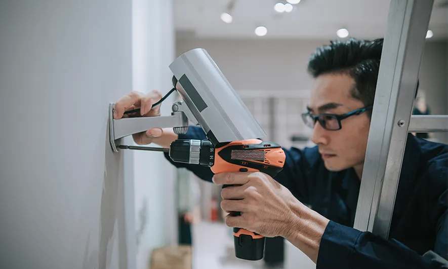A tech installs a security camera