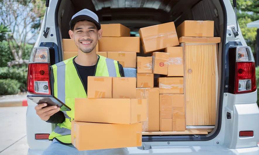 A delivery person holding cardboard packages