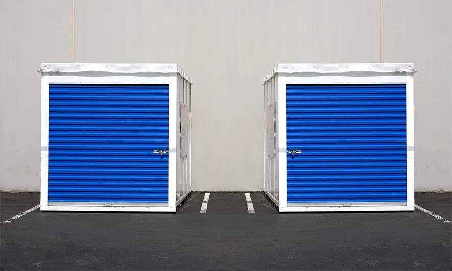 Two large storage containers in a parking lot