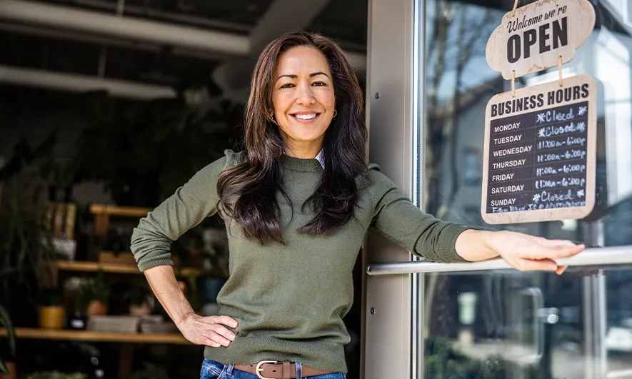 Small business owner stands at the door of their store