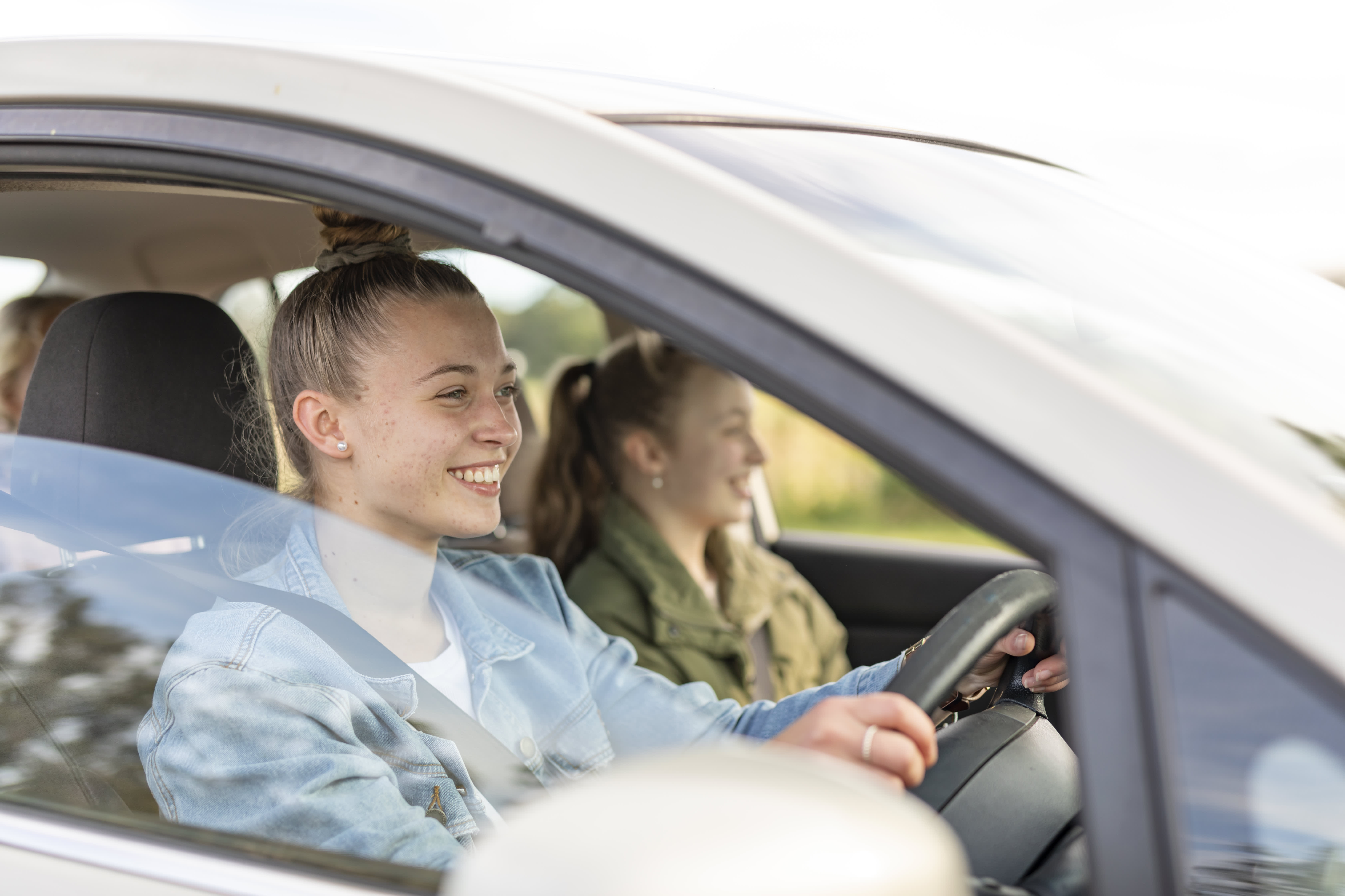 A teenager driving with friends in the car