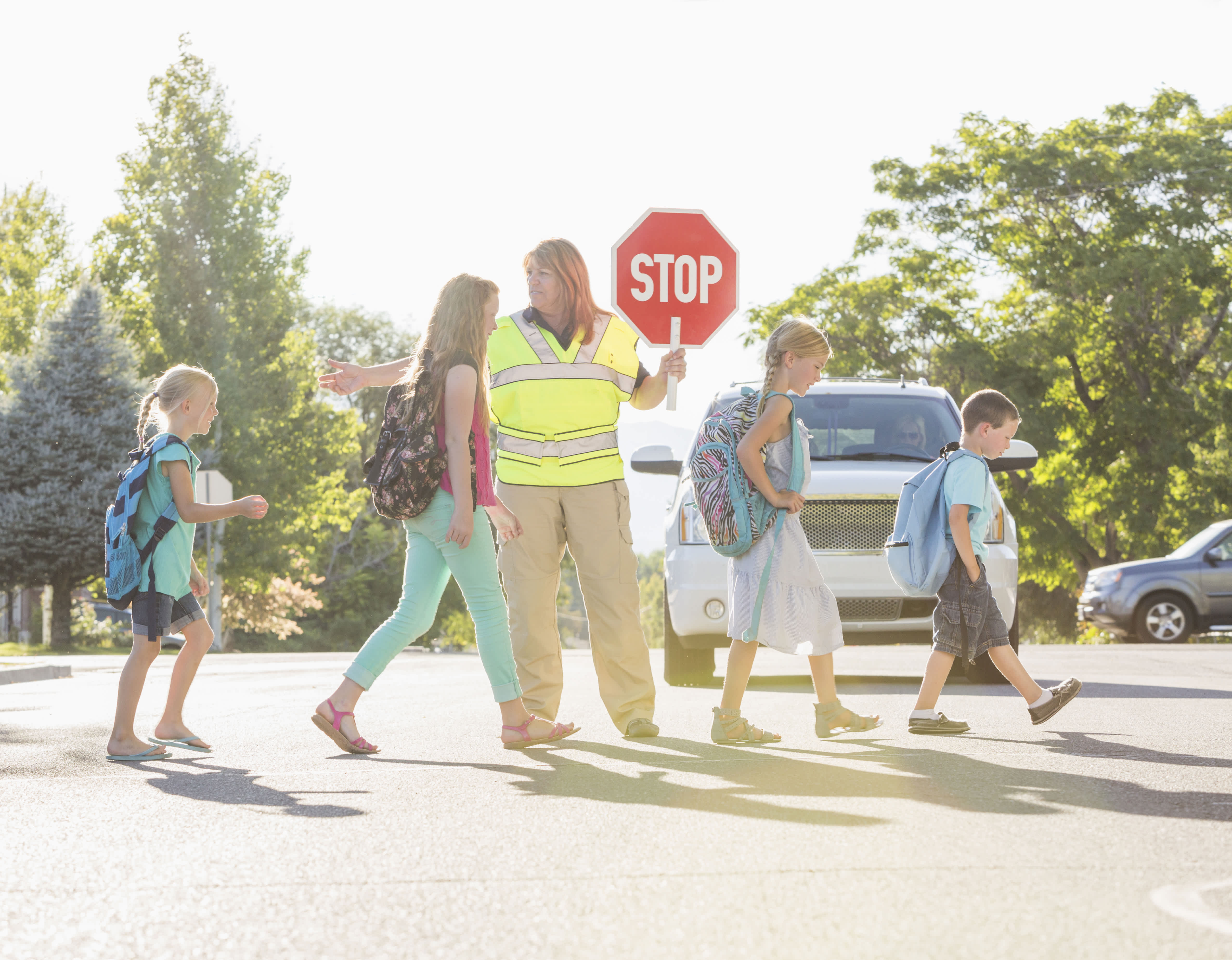 A crossing guard helping kids across the street