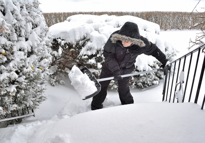 Person shoveling snow from their front steps