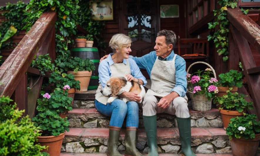 A middle-aged couple sit on a beautiful deck