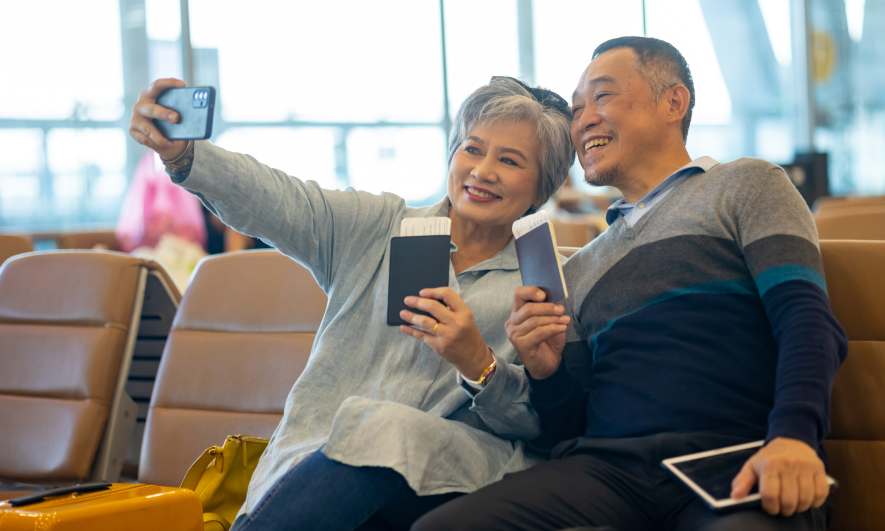A couple posing with their passports in an airport