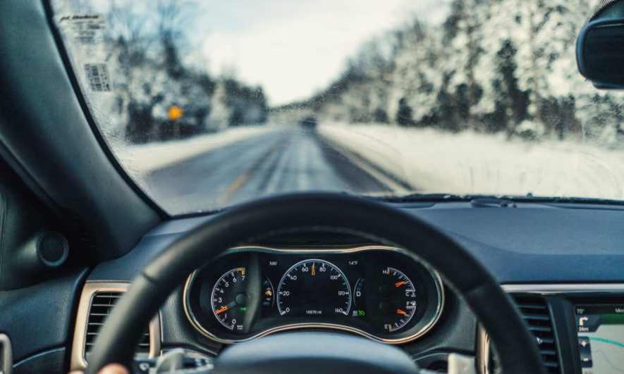 dashboard of a car with snowy road in background