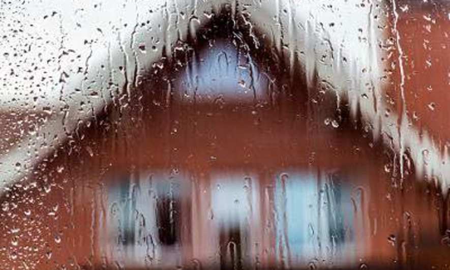 Rain on a window, facing a home