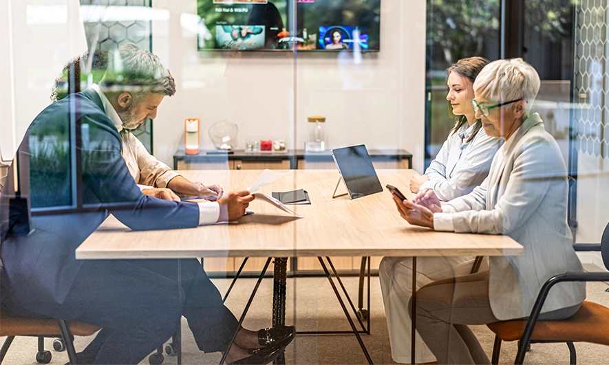 Professionals meeting around a conference table in a modern office.