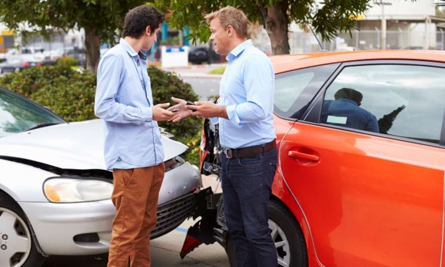 Two people talking after a car crash