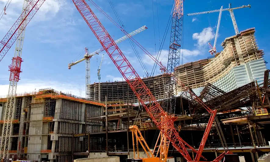 Building, with scaffolding throughout, under construction in the middle of a city.