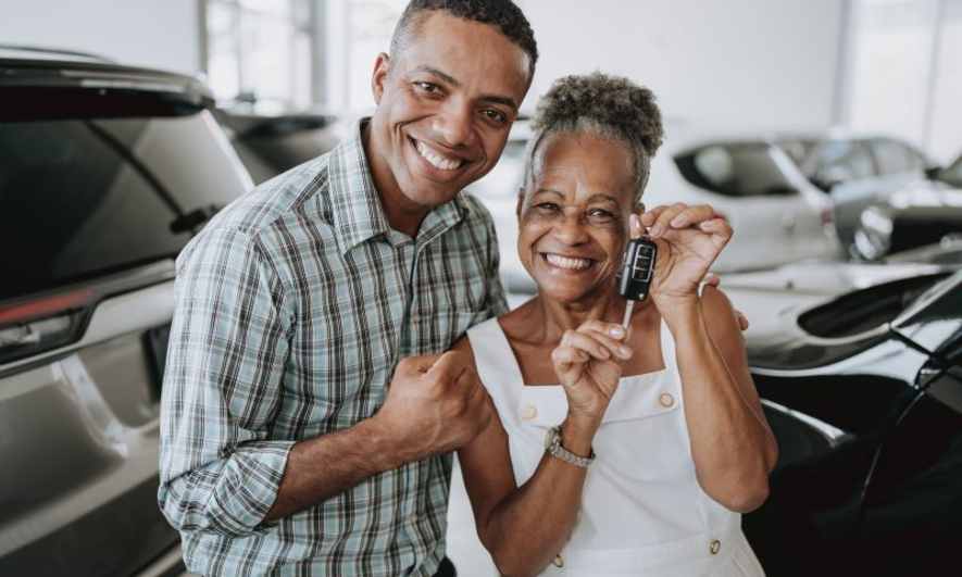 Two people holding the keys to a new car