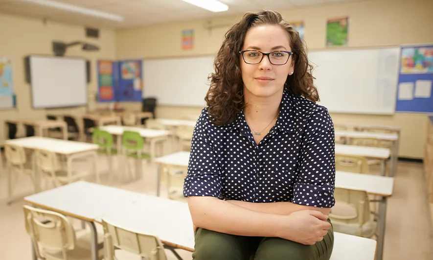 Young teacher sitting in an empty classroom