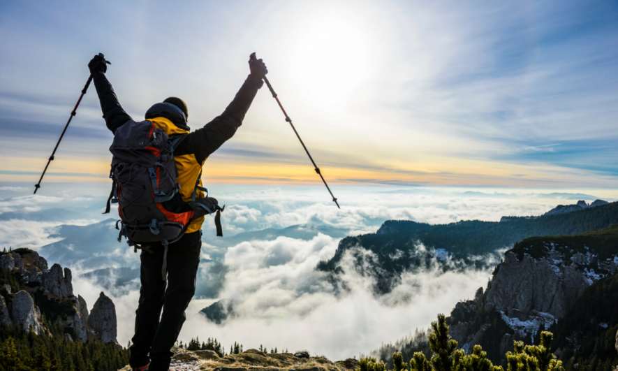 Backpacker gets to the top of a mountain